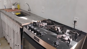 Una cocina con encimera de granito, estufa de acero inoxidable y un fregadero.
