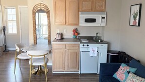 A compact kitchen with wooden cabinets, a microwave, a toaster, and a sink. - Beautiful Studio Apartment With King Sized Bed Just Blocks From the Beach! (Bethany Beach)