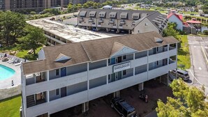 A multi-story hotel with a swimming pool, parking area, and a sign indicating 'Hotel Beachside.' - Beautiful Studio Apartment With King Sized Bed Just Blocks From the Beach! (Bethany Beach)