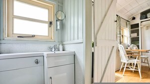 A room with a window, a sink, a chair, and a table. - Host Stay Shepherds Delight (Harleston)
