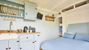 Un dormitorio con cama, mesita de noche, cómoda y ventana.