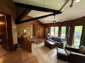 Ein geräumiger Wohnbereich mit Holzboden, einer Sofagarnitur, einem Couchtisch und einem Fernseher.