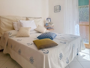 A bed with a nautical-themed bedspread, a headboard, and several pillows. - Coniglio Beach by Interhome (Villasimius)