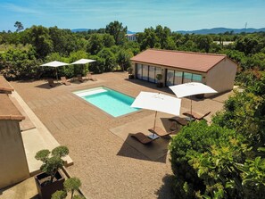 A swimming pool with sun loungers and umbrellas, surrounded by a garden and a building with a tiled roof. - Villa with top-of-the-range amenities Swimming pool and fitness room (San-Gavino-di-Carbini)