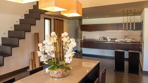 A modern kitchen with dark cabinetry, a central island, and pendant lighting. - Villa with top-of-the-range amenities Swimming pool and fitness room (San-Gavino-di-Carbini)
