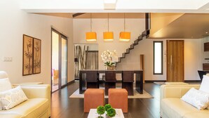 A modern living room with a sofa, ottoman, and a coffee table with decorative items. - Villa with top-of-the-range amenities Swimming pool and fitness room (San-Gavino-di-Carbini)