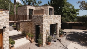 A stone building with a wooden deck, potted plants, and a view of trees. - Casacon Disco hotel Sirolo (Sirolo)