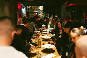 Une salle à manger intérieure bondée, avec des tables et beaucoup de monde.