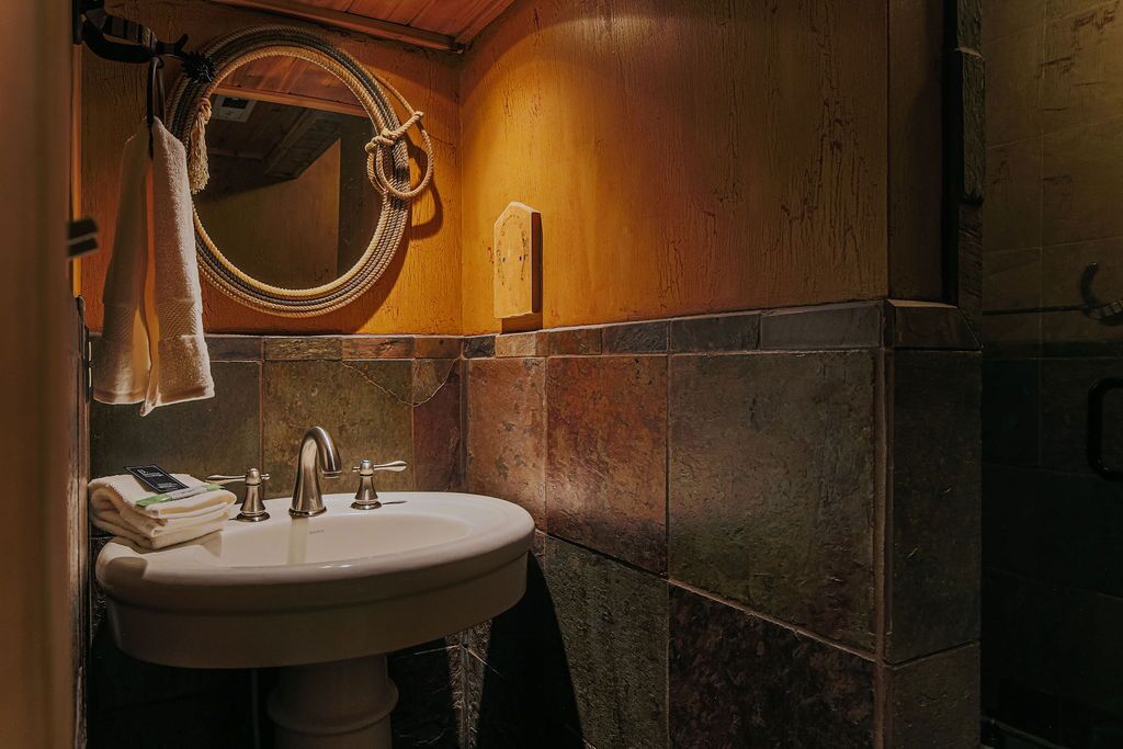 Ein Badezimmer mit einem weißen Waschbecken, einem Spiegel und einem Handtuchhalter.