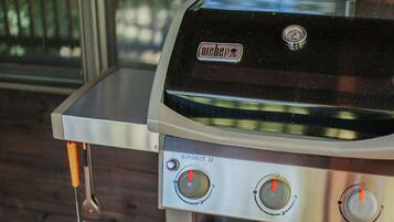 A Weber Spirit II grill with two control knobs and a temperature gauge.