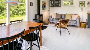 Una sala de estar acogedora con chimenea, un sofá y un comedor con sillas.