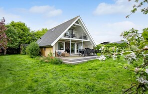 A modern house with a large deck, a covered outdoor seating area, and a well-maintained garden. - Amazing home in Assens with WiFi (Assens)