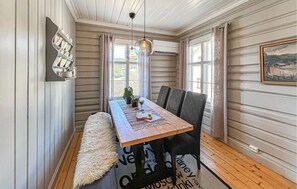 A dining area with a wooden table, chairs, a fluffy rug, and a hanging light fixture. - Gorgeous home in Svatsum with WiFi (Svatsum)