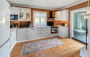 A modern kitchen with white cabinetry, a built-in oven, a coffee machine, and a large window. - Gorgeous home in Svatsum with WiFi (Svatsum)