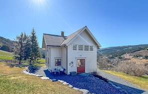 A white house with a red door and windows, surrounded by a gravel driveway and a stone wall. - Gorgeous home in Svatsum with WiFi (Svatsum)