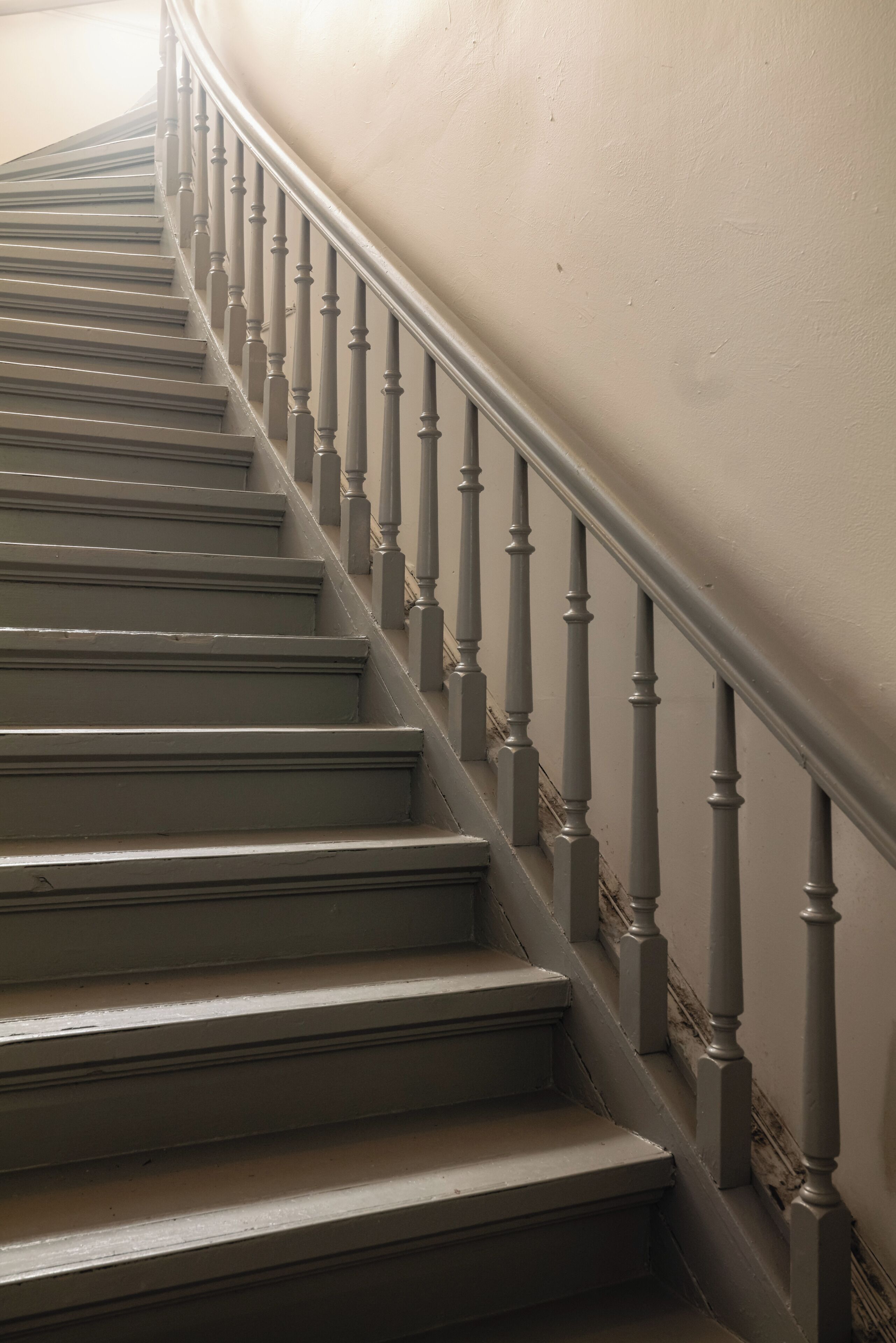 A staircase with a handrail and a wall.