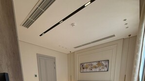 Een slaapkamer met een bed, nachtkastjes, een deur en een ventilatie rooster.