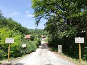 A gravel road leading to a rural area with signs indicating 'La Vergne' and 'Chambres d'hôtes.'