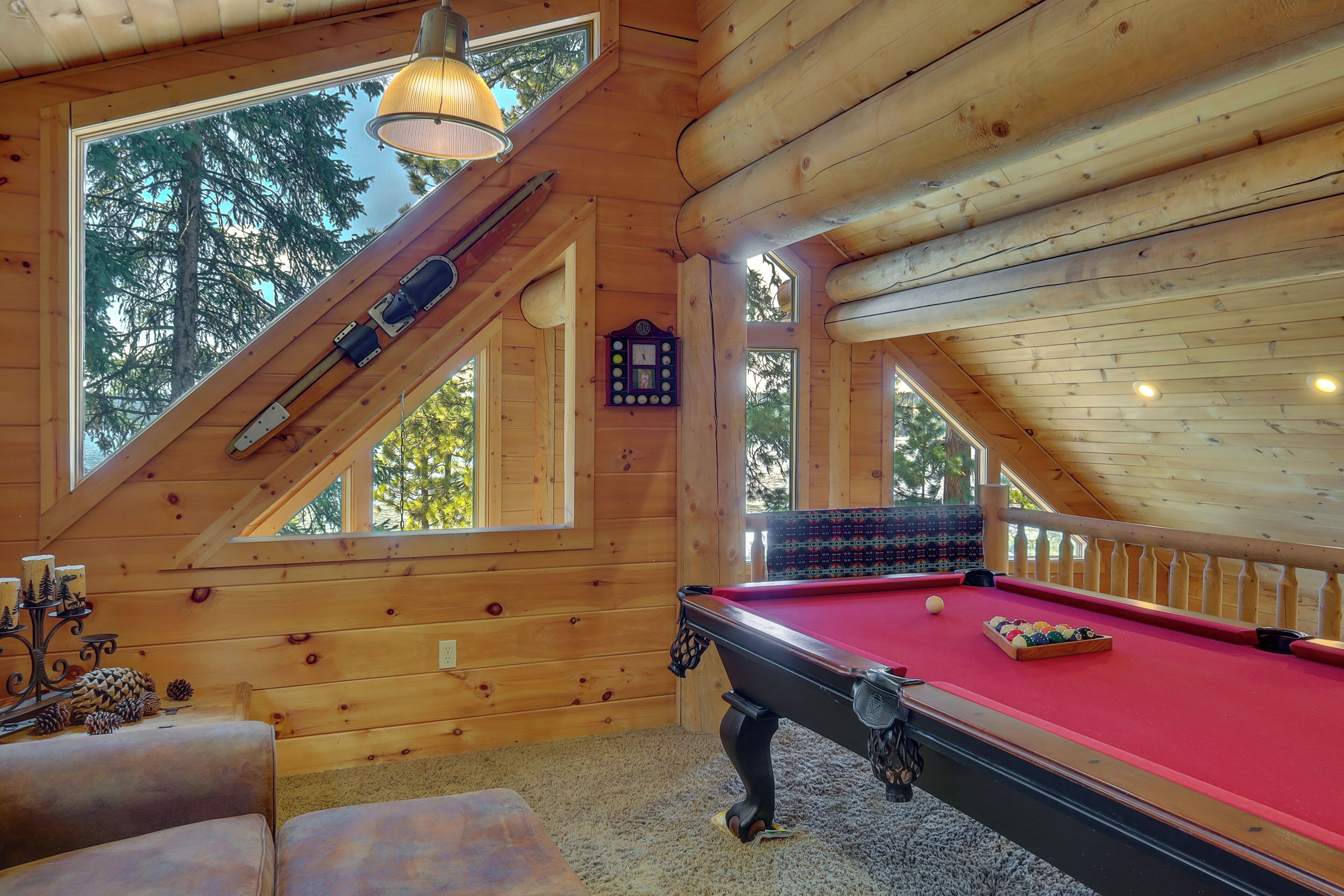 Een houten interieur met een biljart, zitplaatsen en een klok.