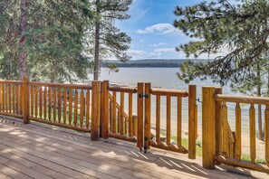 A wooden deck with a railing overlooking a lake. - Beach & Dock Access! Waterfront Payette Lake Home (McCall)