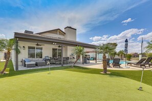 A modern house with a patio, outdoor seating, and a swimming pool. - Pool & Mini Putting Green! Peoria Desert Oasis (Peoria)