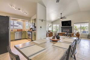 Eine geräumige Küche mit Essbereich, Kamin und Deckenventilator.