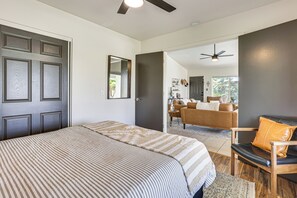 Ein Schlafzimmer mit Bett, Stuhl, Schreibtisch und einer Tür.