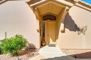 A house with a beige exterior, a front door, a butterfly decoration, and a small tree. - Golf, Hike & Unwind: Oro Valley Townhome w/ Patio! (Oro Valley)
