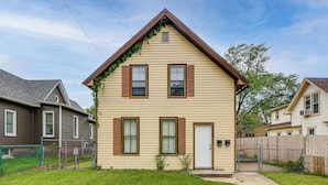 A two-story house with a front door, two windows with shutters, and a small front yard. - Extended-stay Apartment in Downtown MC Near Lake (Michigan City)