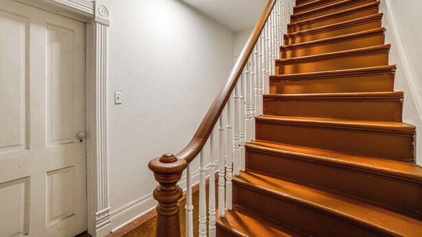 A staircase with wooden steps and white balusters. - Extended-stay Apartment in Downtown MC Near Lake (Michigan City)