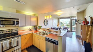 A modern kitchen with stainless steel appliances, wooden cabinets, and a large island with a sink. - Dual Chelan Resort Suites: Pool, Hot Tub & Beach (Chelan)