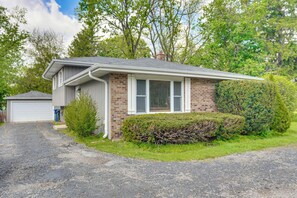 A residential house with a garage, a brick exterior, and a well-maintained lawn.