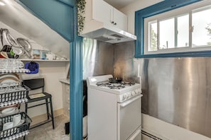 A compact kitchen with a white stove, stainless steel cabinets, and a window. - 'nanas Tiny Flat' East Side Charmer Near Brown (Providence)