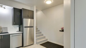 Una cocina moderna con electrodomésticos de acero inoxidable, lavavajillas y gabinetes oscuros.