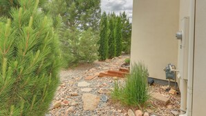 Un sendero de grava con pinos y la fachada de un edificio.
