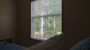 Una habitación con ventana, cama y almohada.