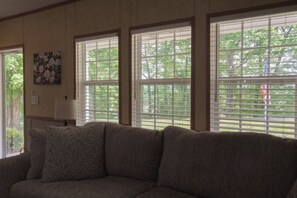A living room with a sofa, a lamp, and a window with blinds. - Lakeview Legacy~Holmes Bend Marina~Walk to Lake (Columbia)