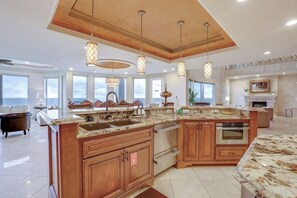 A spacious kitchen with wooden cabinets, stainless steel appliances, and pendant lighting. - Bayfront Villa w/ Million-dollar Views in Seabrook (Seabrook)