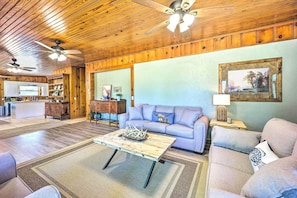 A living room with a wooden ceiling, a sofa, a coffee table, and a television in the background. - 3-unit Group Retreat! 2 Mi to Wolf Creek Boat Ramp (Grove)