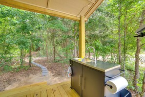 A covered outdoor kitchen with a sink and a barbecue grill, surrounded by trees. - Tweet Suite - Studio Getaway 7 Mi to Dtwn Tyler (Tyler)