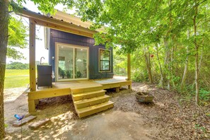 A wooden deck leading to a cabin with a glass door, surrounded by trees. - Tweet Suite - Studio Getaway 7 Mi to Dtwn Tyler (Tyler)