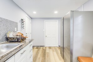 A kitchen with a sink, countertop, cabinets, a door, and a refrigerator. - Near Southern Regional MC! Commuter-friendly Base (Riverdale)