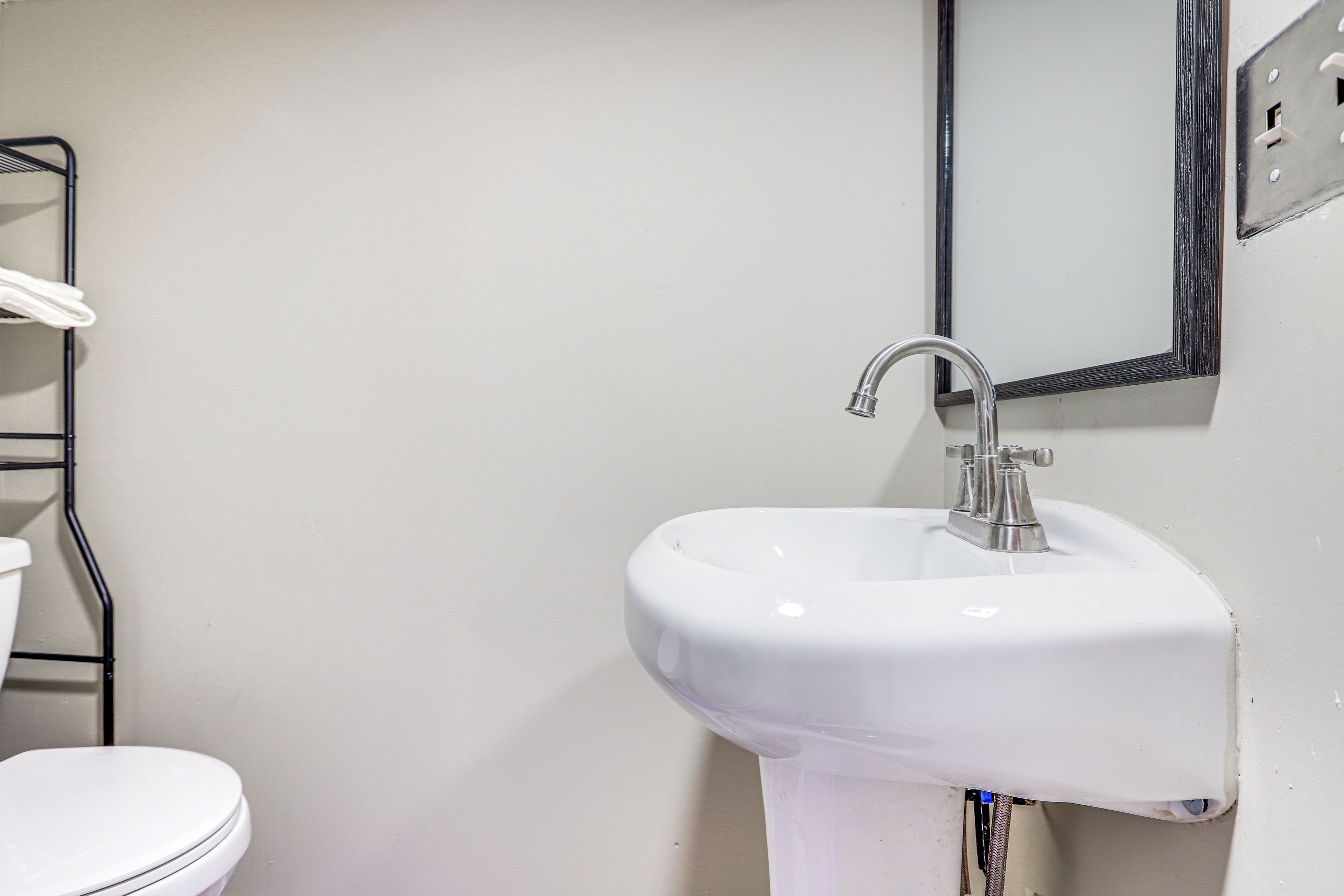 Une salle de bain avec un lavabo blanc, des toilettes et un porte-serviettes en métal.