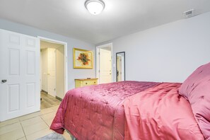 A bedroom with a bed, a door, a hallway, and a painting on the wall. - Near Southern Regional MC! Commuter-friendly Base (Riverdale)