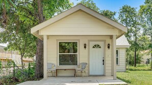 A small, single-story building with a front porch, two chairs, and a door. - Updated Craftsman in Historic Southside Fort Worth (Fort Worth)