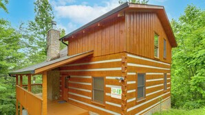 A log cabin with a porch, a chimney, and a sign indicating it is a vacation rental. - Smoky Mtn Oasis w/ Hot Tub! 5 Mi to Skyland Ranch (Sevierville)