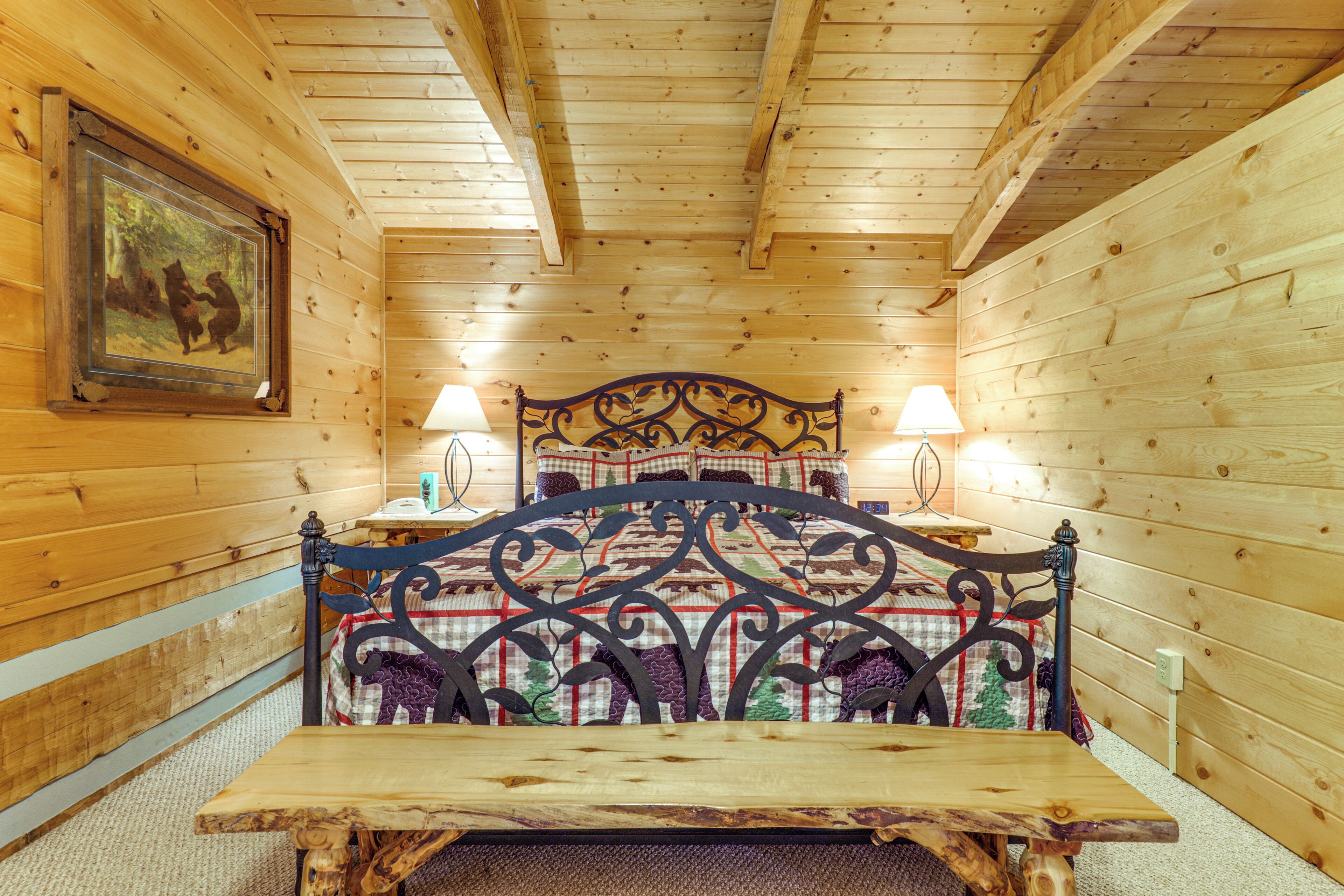 Une chambre rustique en bois, avec un lit, deux lampes de chevet et un tableau encadré au mur.