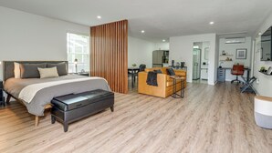 Een moderne slaapkamer met een bed, nachtkastje en een houten scheidingswand.