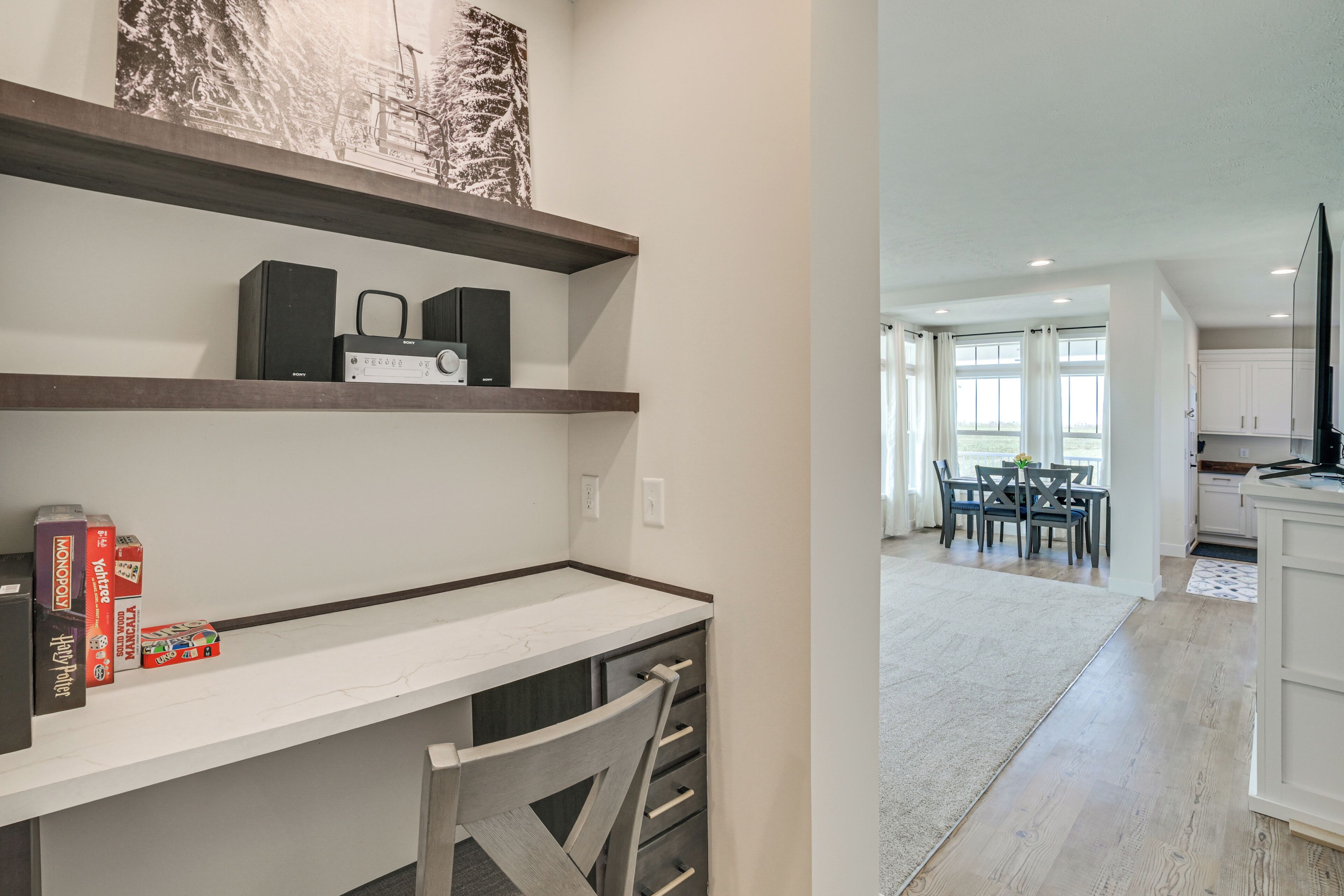 Eine moderne Küche mit weißen Schränken, einer Holzausziehtafel und einem Essbereich mit Tisch und Stühlen.