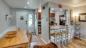 Una cocina moderna con una isla central, mesa de comedor de madera y sillas.